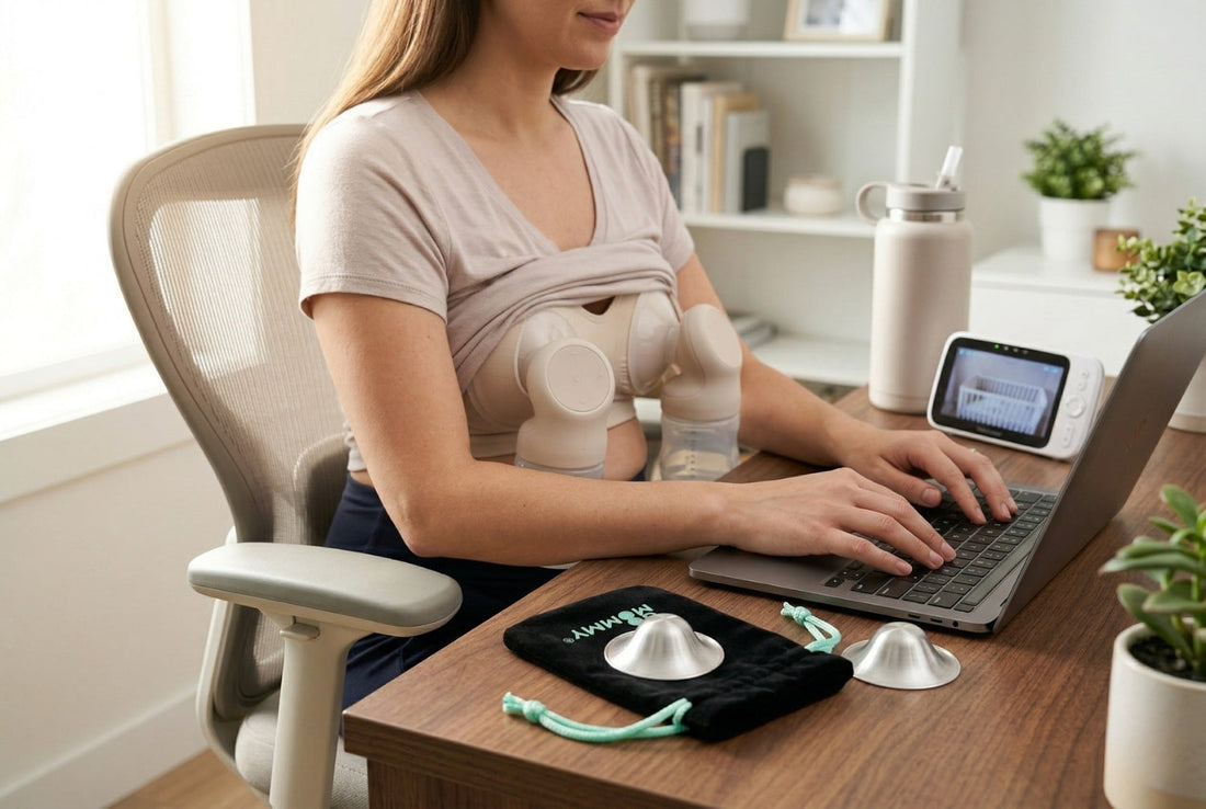 Mother working on laptop hands-free while double electric pumping with silver nursing cups in velvet pouch on desk beside her