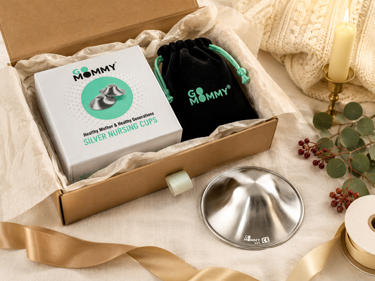 Silver nursing cups gift box styled with holiday ribbon and a cozy blanket