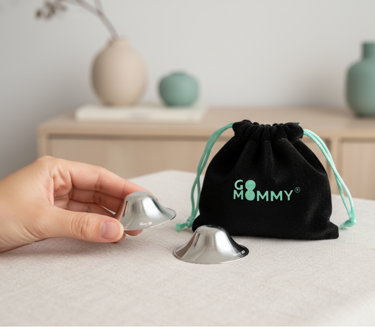 pair of silver nursing cups with black velvet Go Mommy pouch on table, soft daylight — Go Mommy
